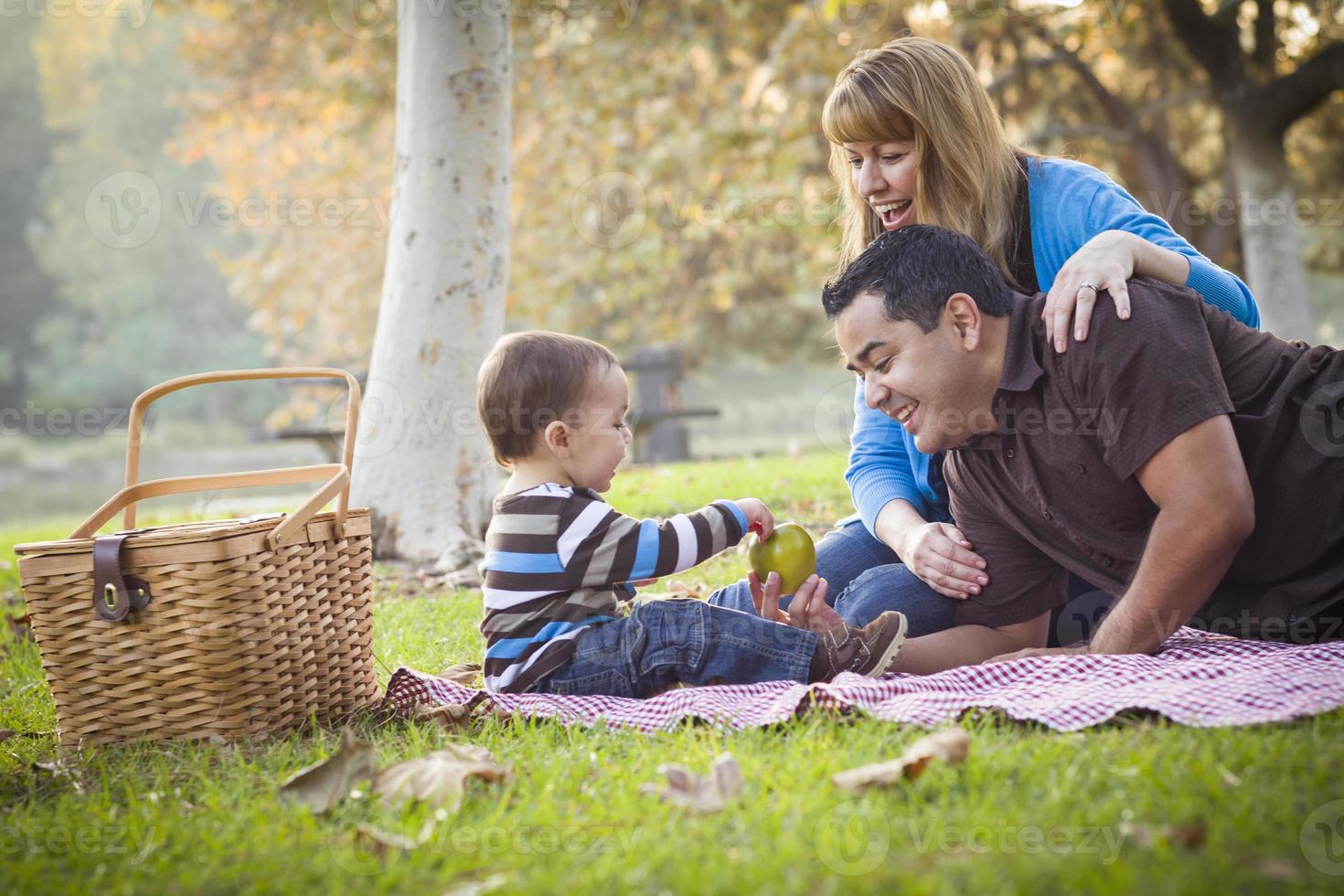 feliz familia étnica de raza mixta haciendo un picnic en el parque foto