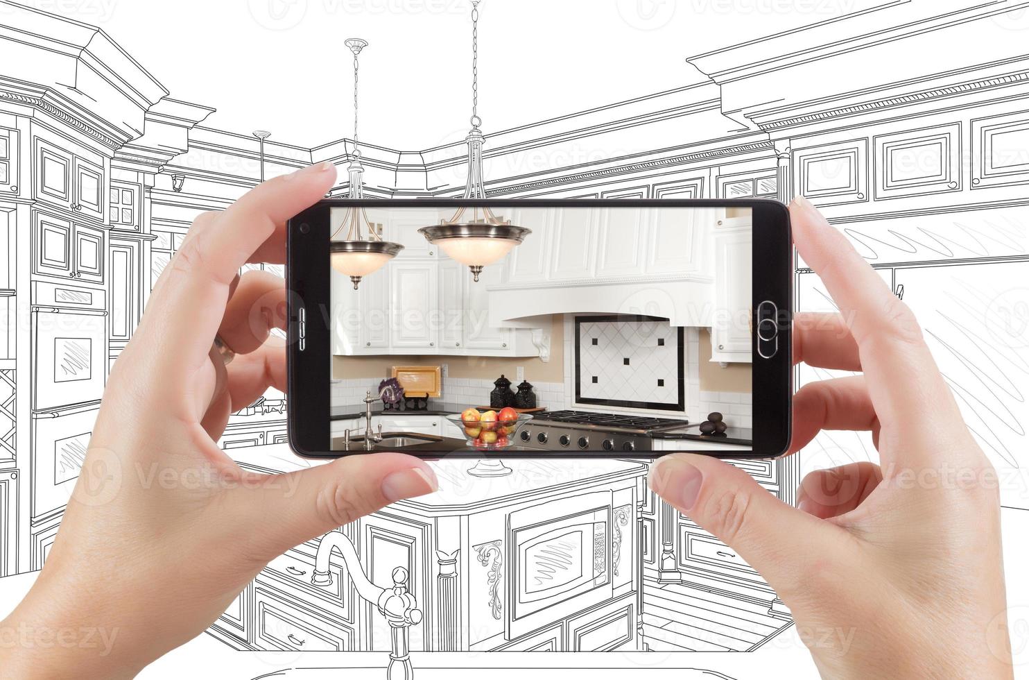 Hands Holding Smart Phone Displaying Photo of Kitchen Drawing Behind