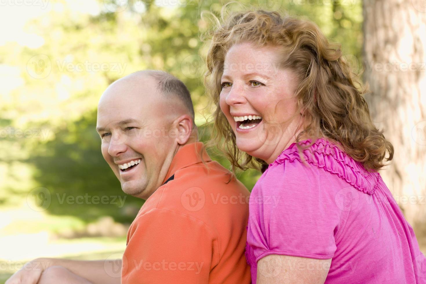 feliz pareja atractiva riendo en el parque foto