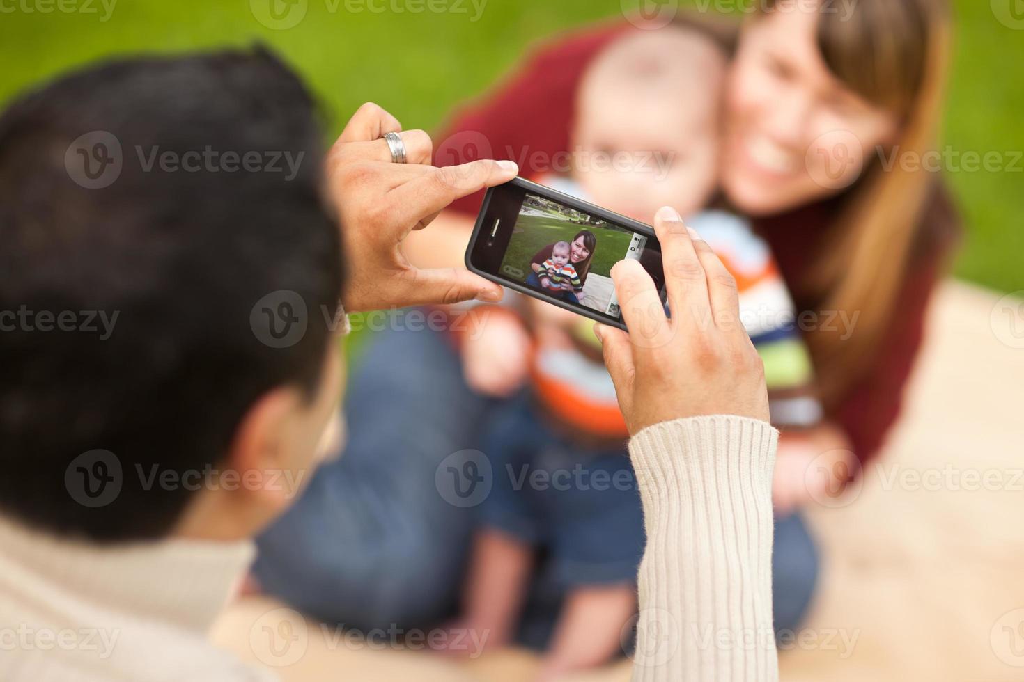 Happy Mixed Race Parents and Baby Boy Taking Self Portraits photo