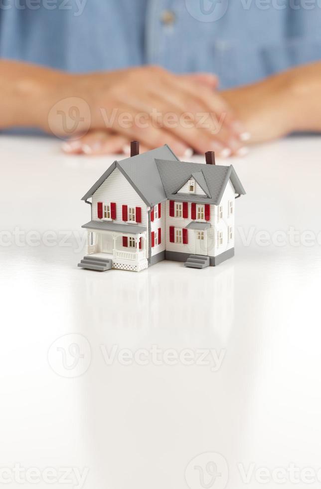Womans Folded Hands Behind Model House photo