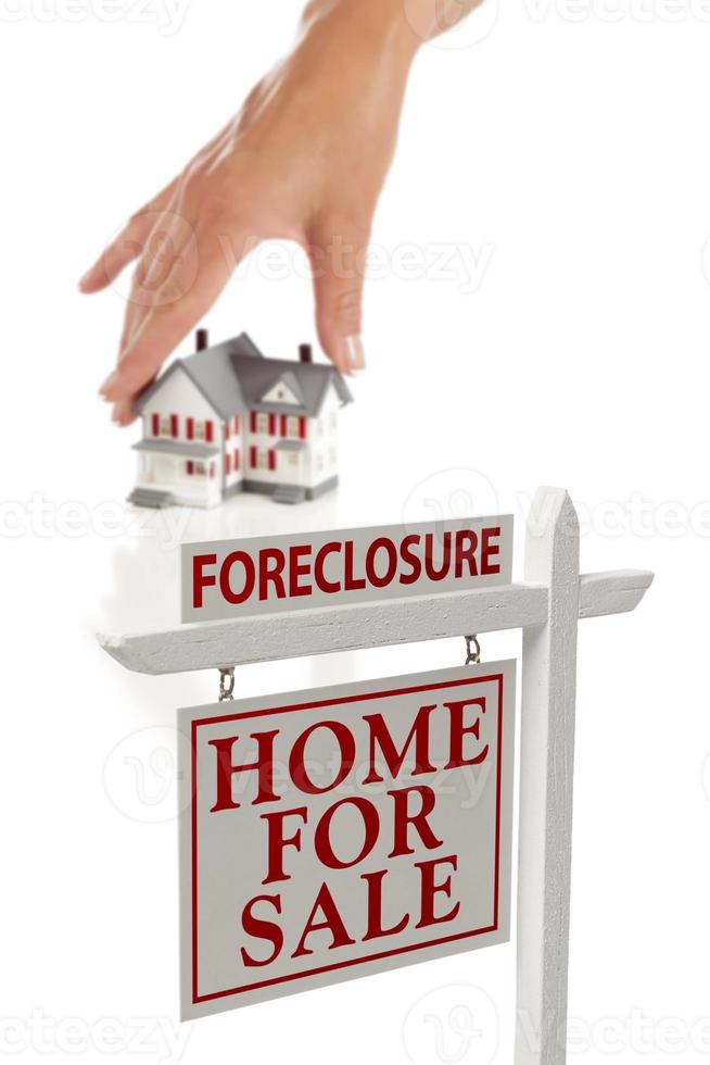 Womans Hand Choosing Home with Foreclosure Real Estate Sign photo