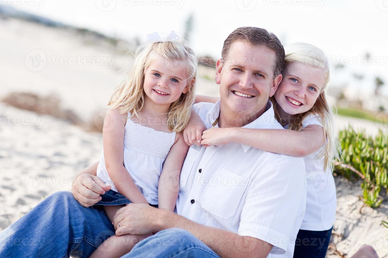 Handsome Dad and His Cute Daughters at The Beach photo