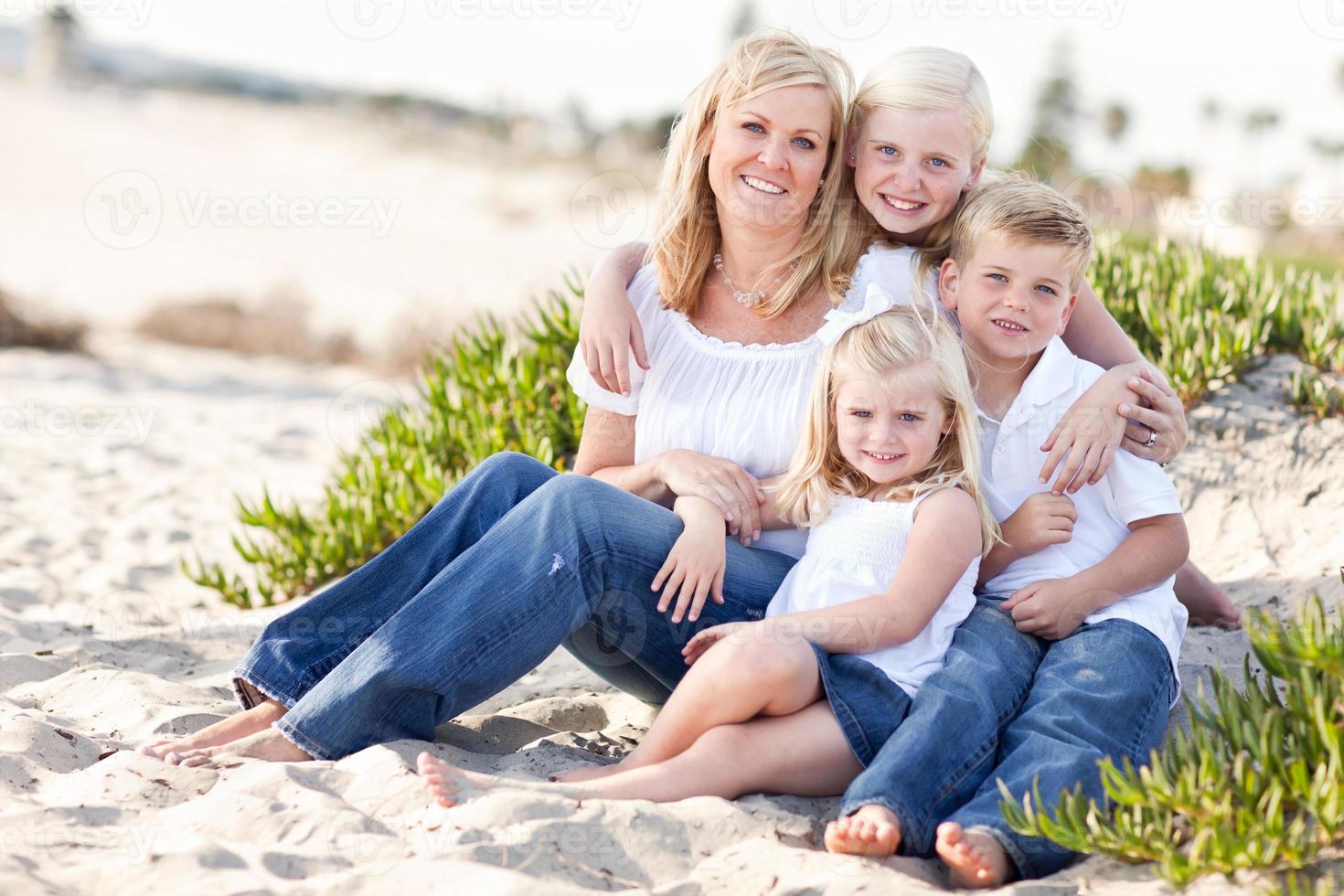 mamá atractiva y sus lindos hijos en la playa foto