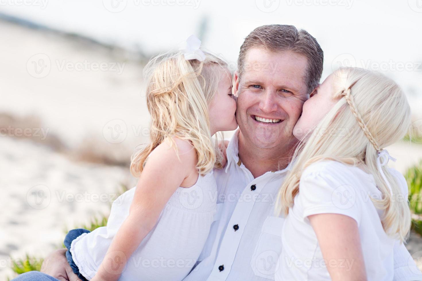 Handsome Dad Getting Kisses from His Cute Daughters photo