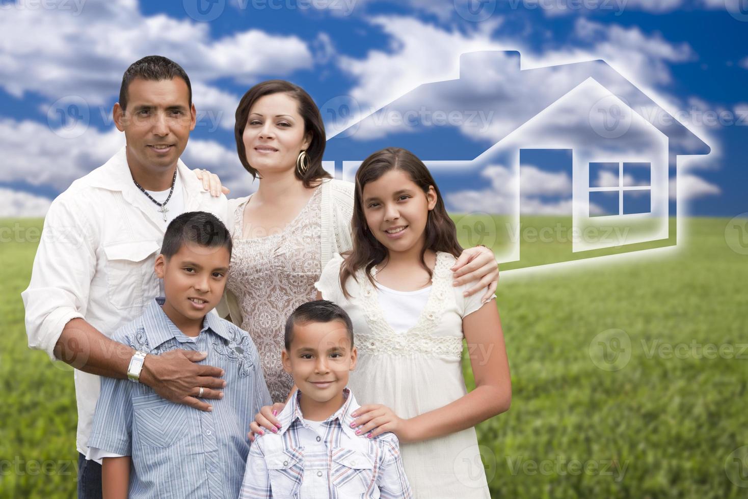 Hispanic Family Standing in Grass Field with Ghosted House Behind photo