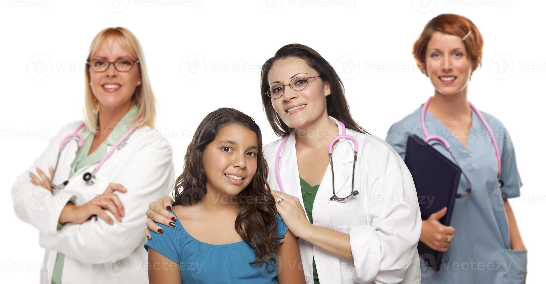 Hispanic Female Doctor with Child Patient and Colleagues Behind photo