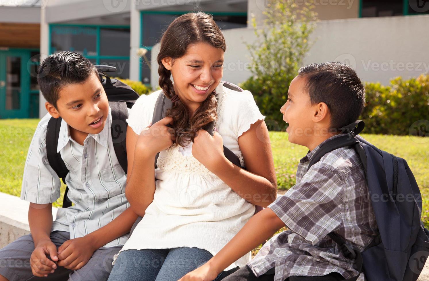 Hispanic Brothers and Sister Talking Ready for School photo