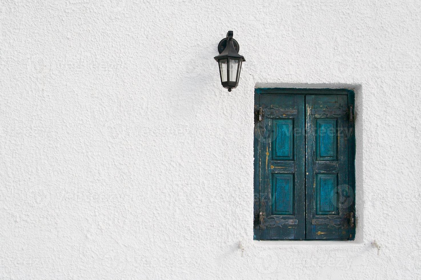 Abstract close-up of Santorini home wall, window and lamp. photo