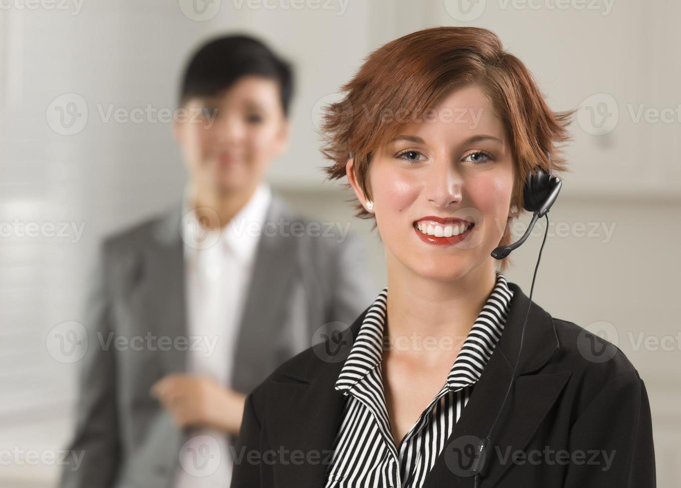 bastante, pelirrojo, mujer de negocios, con, auriculares, en, oficina foto