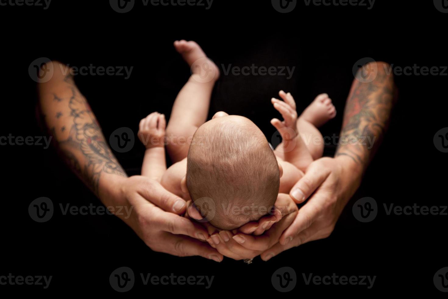 Hands of Father and Mother Hold Newborn Baby on Black photo