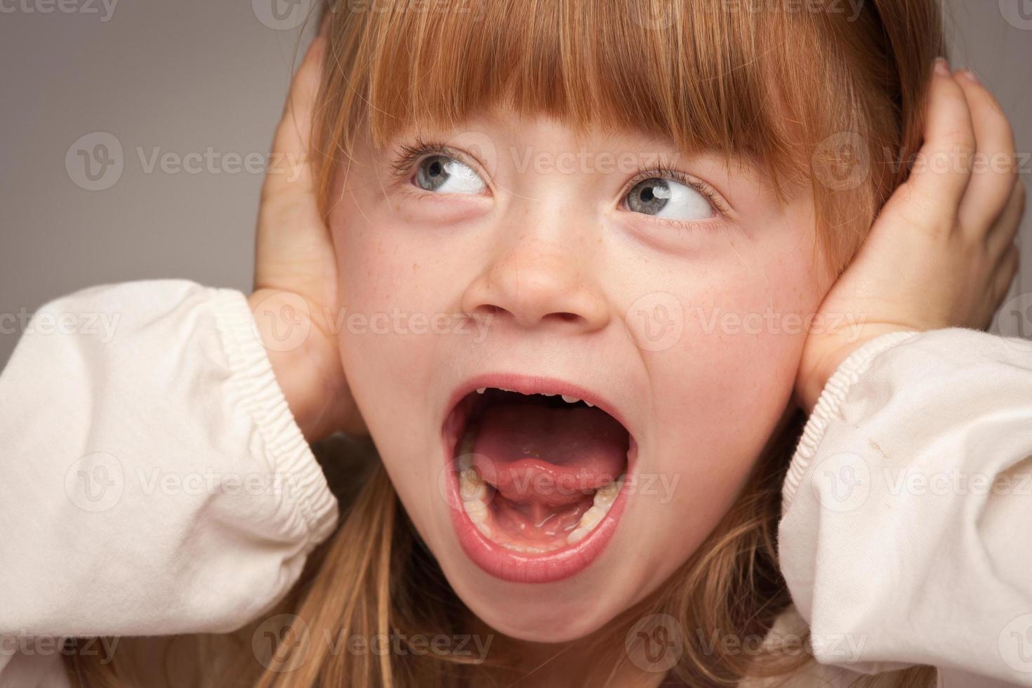 Fun Portrait of an Adorable Red Haired Girl on Grey photo