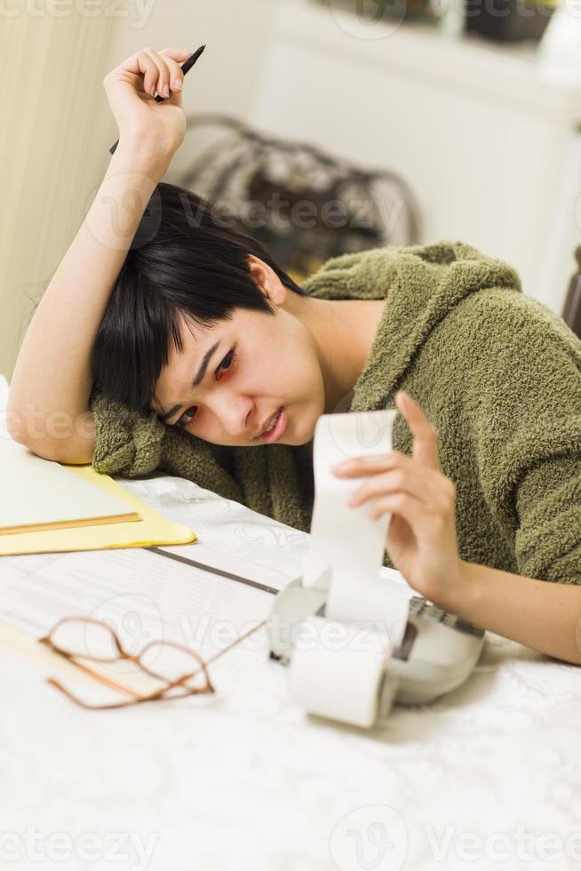 Multi-ethnic Young Woman Agonizing Over Financial Calculations photo