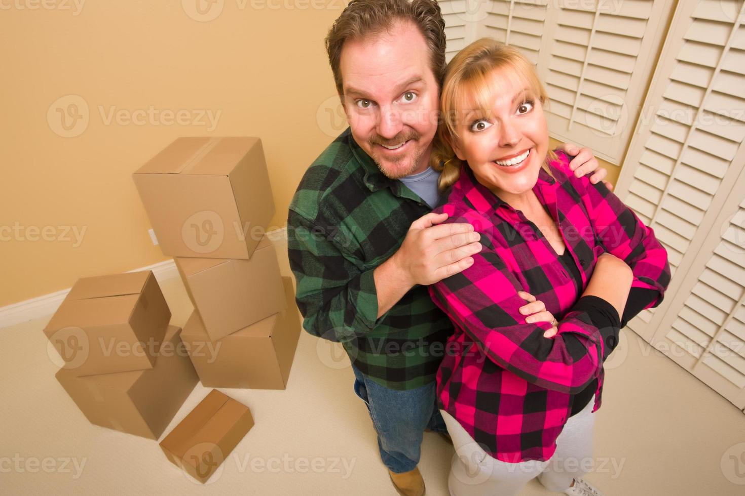 Proud Goofy Couple and Moving Boxes in Empty Room photo