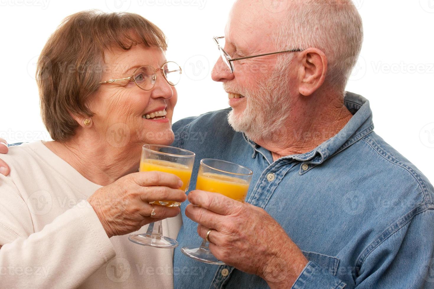 Happy Senior Couple with Glasses of Orange Juice photo