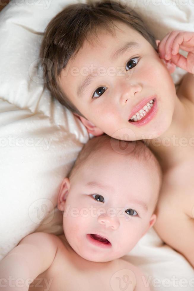 Mixed Race Chinese and Caucasian Baby Brothers Having Fun Laying on Their Blanket photo