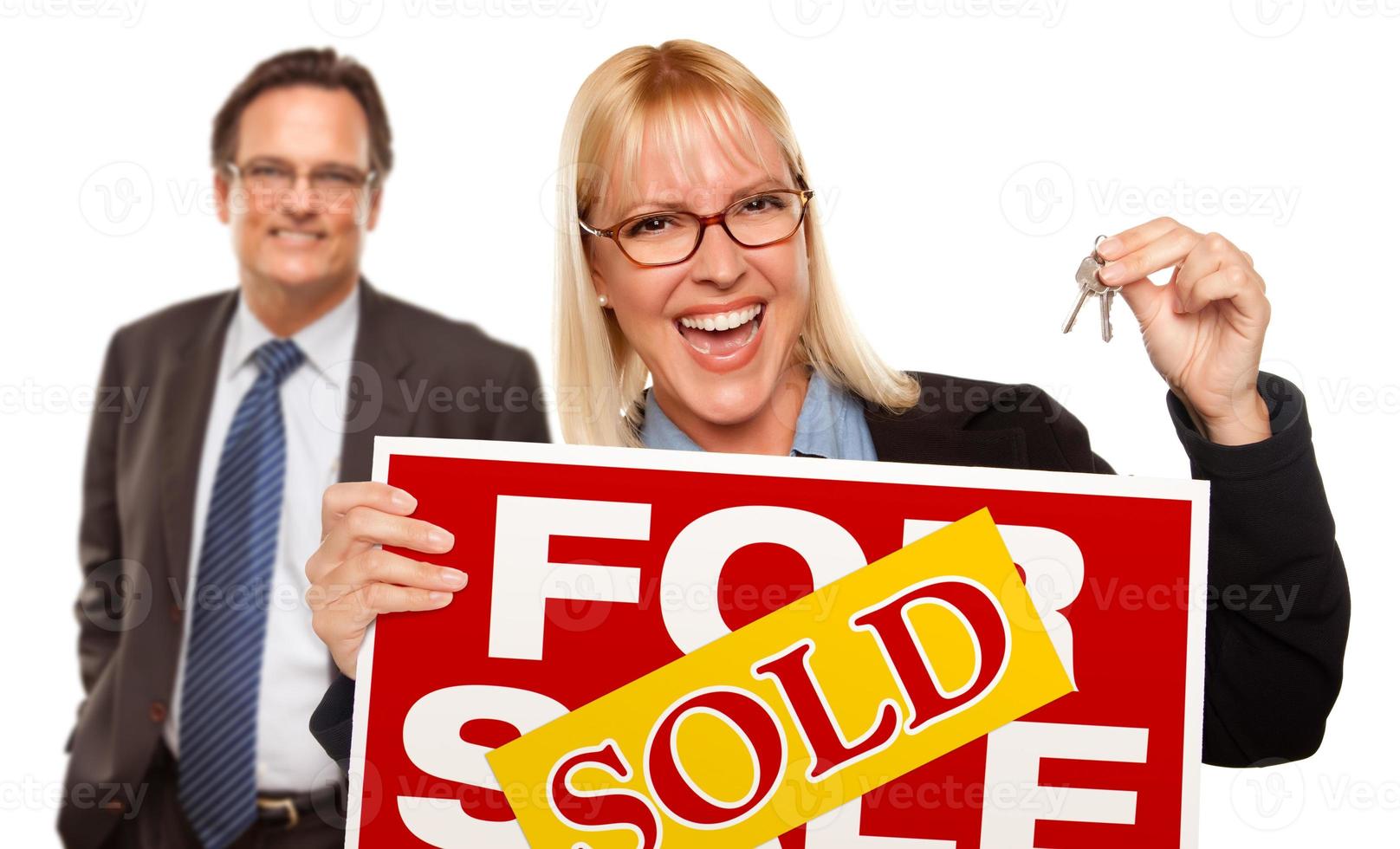 Man with Blonde Woman Holding Keys and Sold For Sale Sign photo