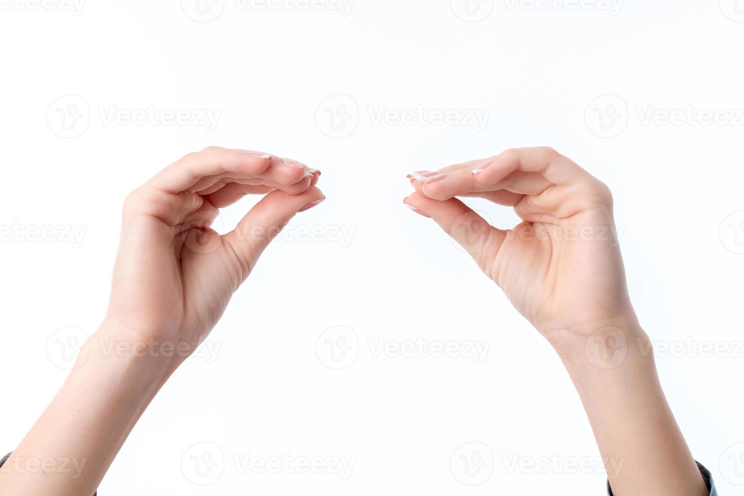 las manos de las mujeres una frente a la otra con los dedos apretados aisladas en el fondo blanco foto