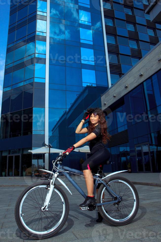 vertical photo of cute brunette sports woman on bicycle