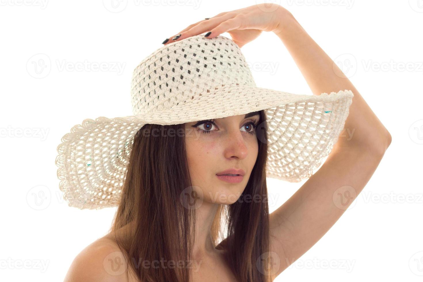 Portrait of an attractive girl in a hat with a large brim which looks toward isolated on white background photo