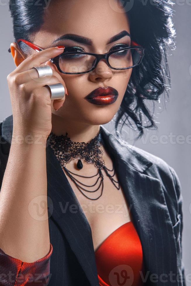 Lovely young teacher with make up and glasses in studio photo