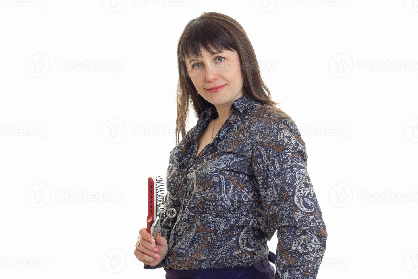 portrait of adult woman with hairstyle tools in hands looking at the camera photo