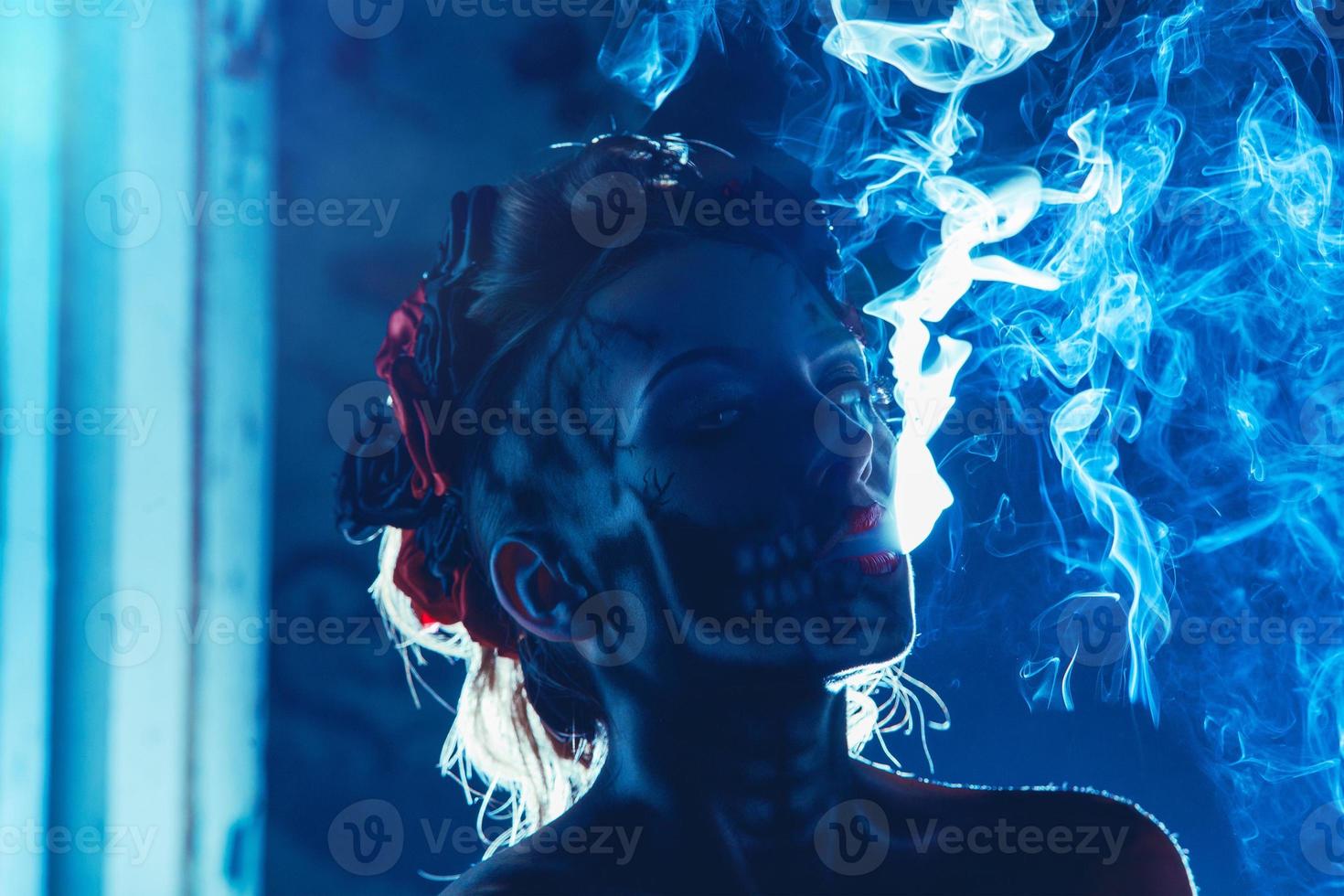 Face art of skull on woman face with smoke photo