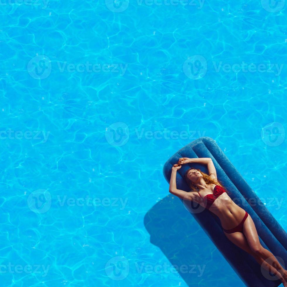 mujer joven en bikini rojo tomando el sol foto