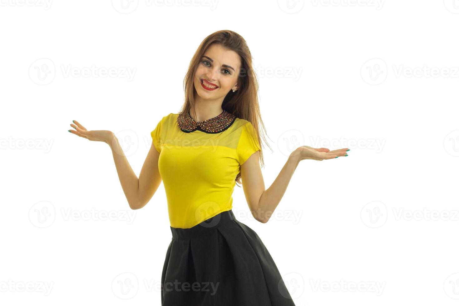 cute pin-up girl in bright clothes stands straight smiles and holds the Palm of your hand on the sides photo