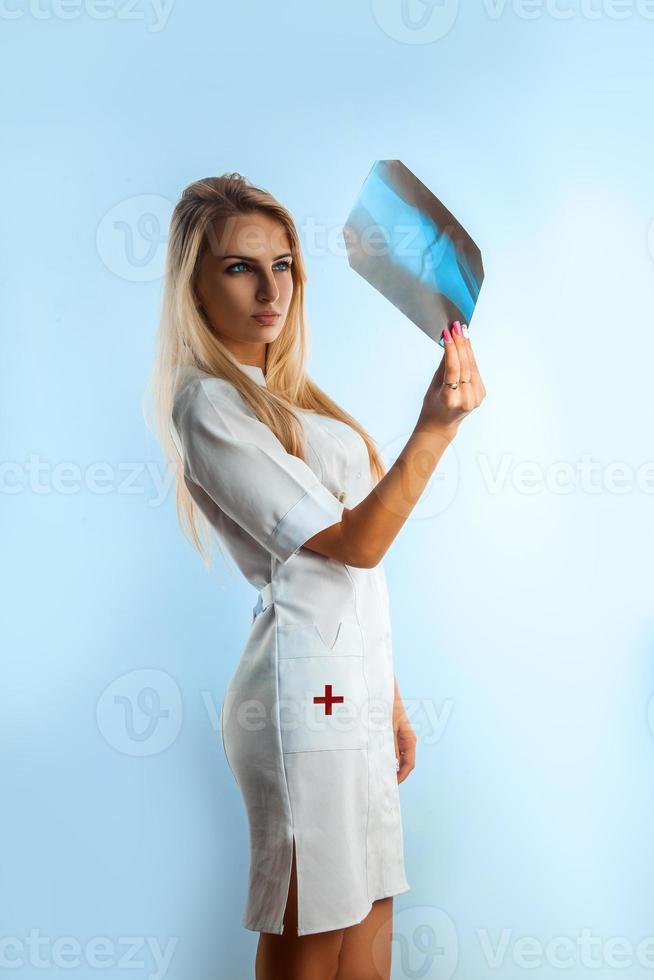 Fashion model nurse looking at radiograph photo