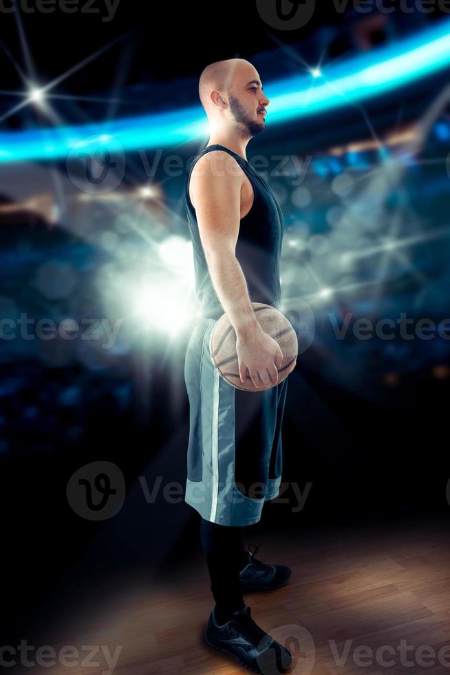 Bald basketball player in the game standing with a ball photo