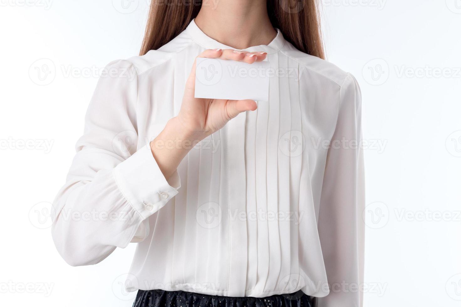 chica en camisa mantiene una hoja de papel de mano aislada sobre fondo blanco foto