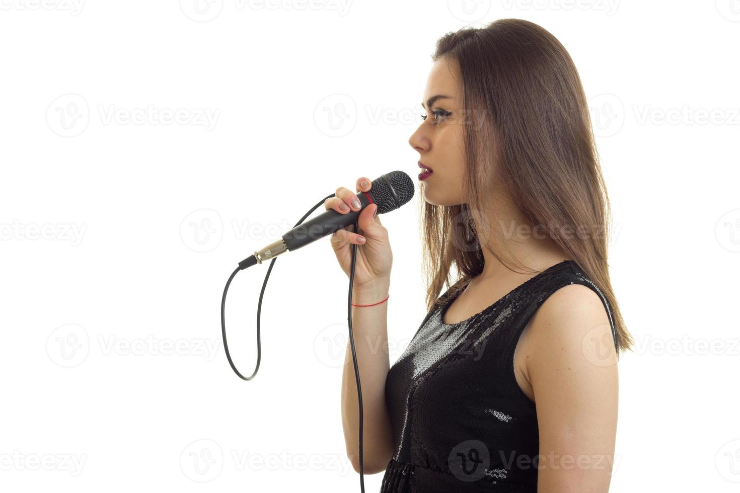 beautiful woman in black dress with microphone in hands photo