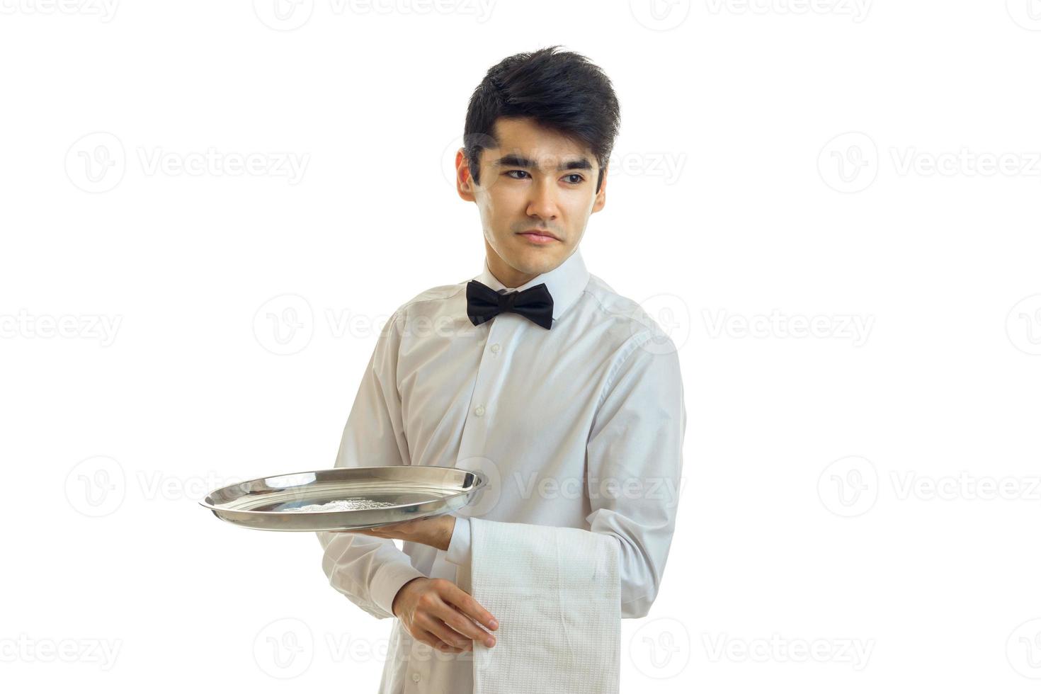 young dark haired waiter holding a tray with a towel and looking toward photo