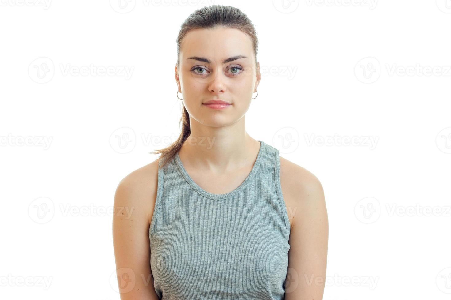 Portrait of a beautiful woman in a gray t-shirt and with the collected hair that stands straight up and seriously looking at camera photo