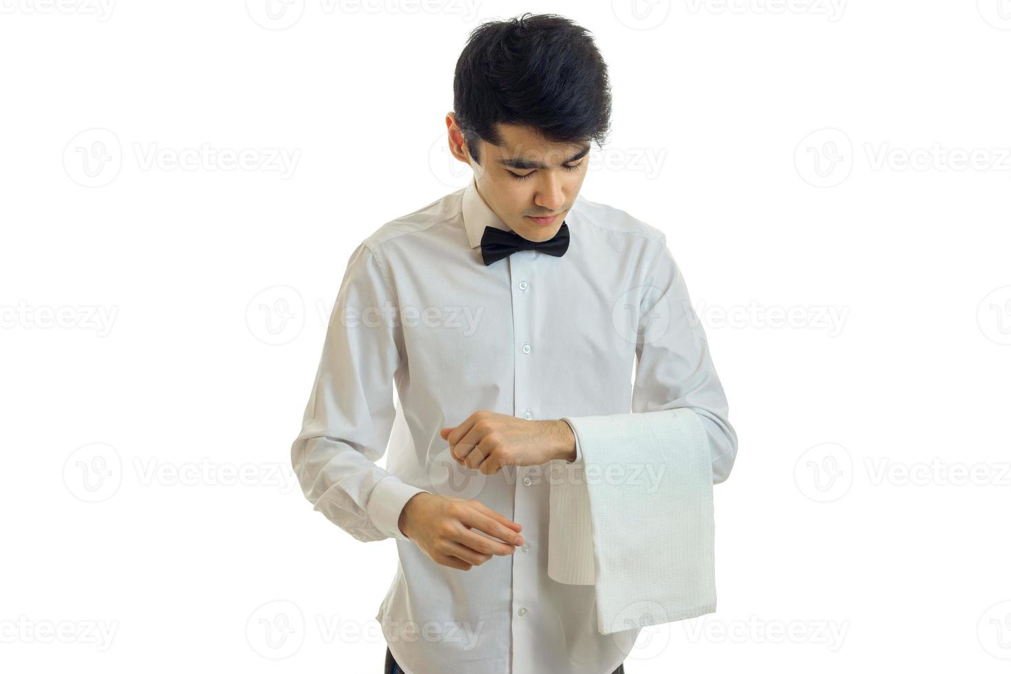 a young waiter in a white shirt tilted his head and keeps on hand a towel photo