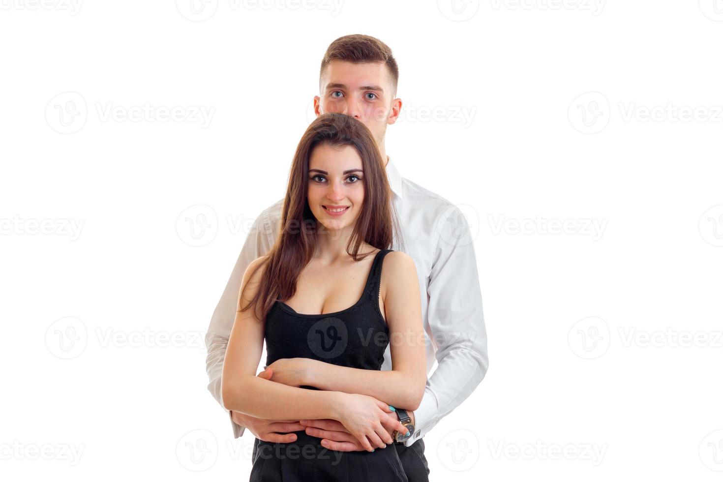 young tall guy behind and embracing beautiful girl's waist photo