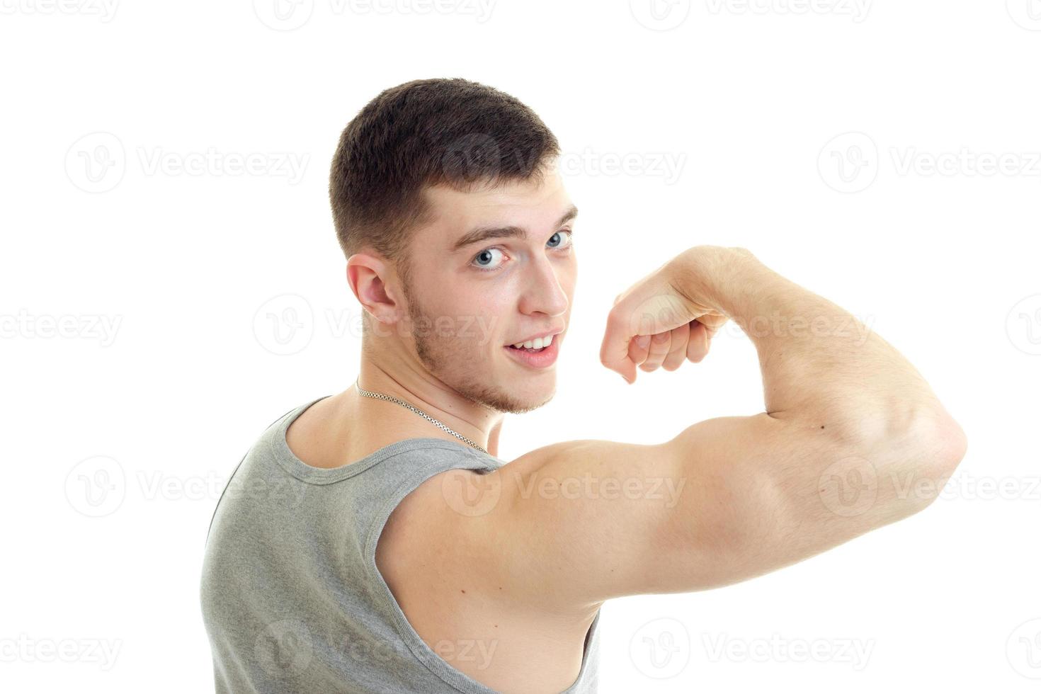 Young sports man showing his biceps and looking at the camera photo