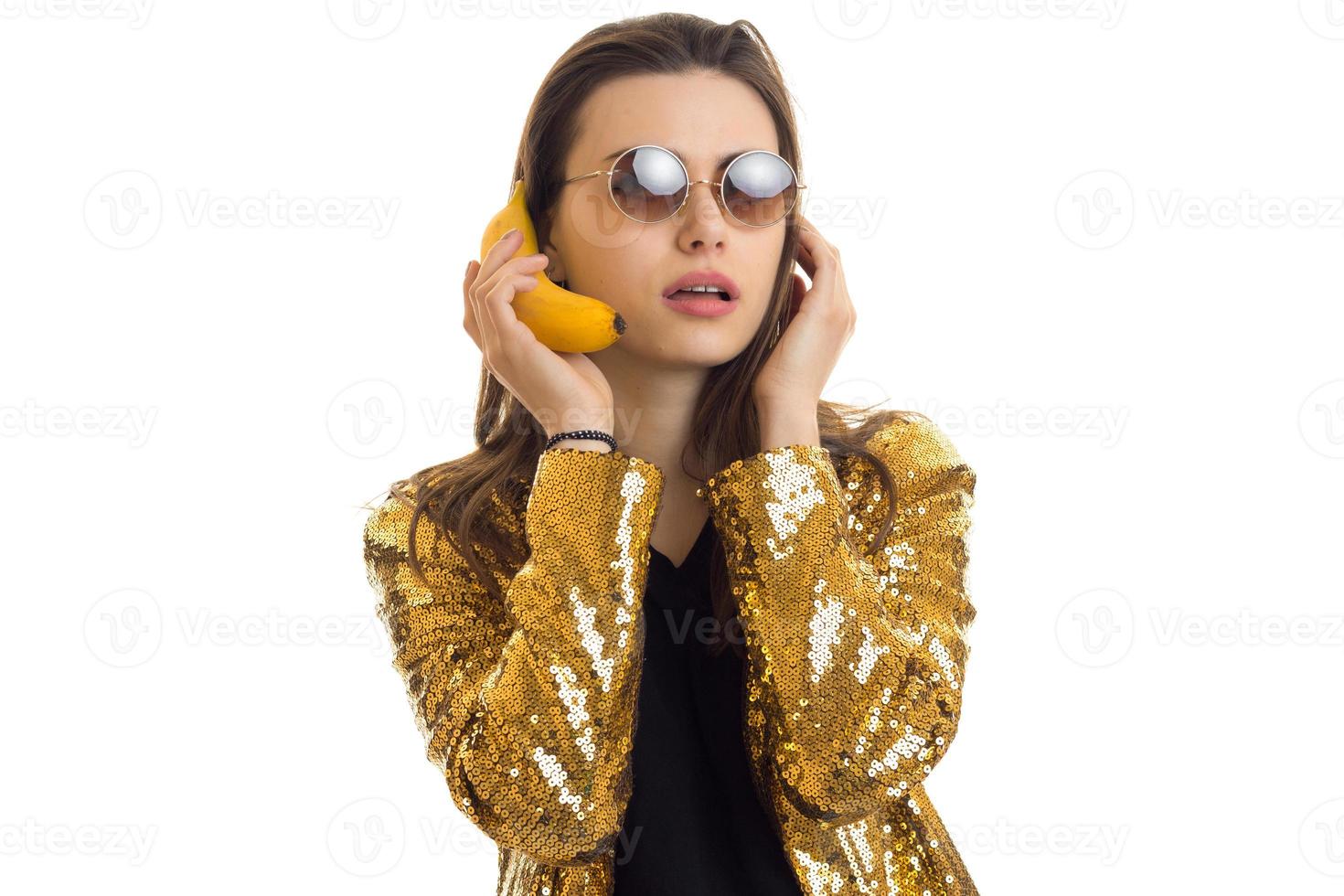 joven mujer con estilo en chaqueta dorada con banan foto