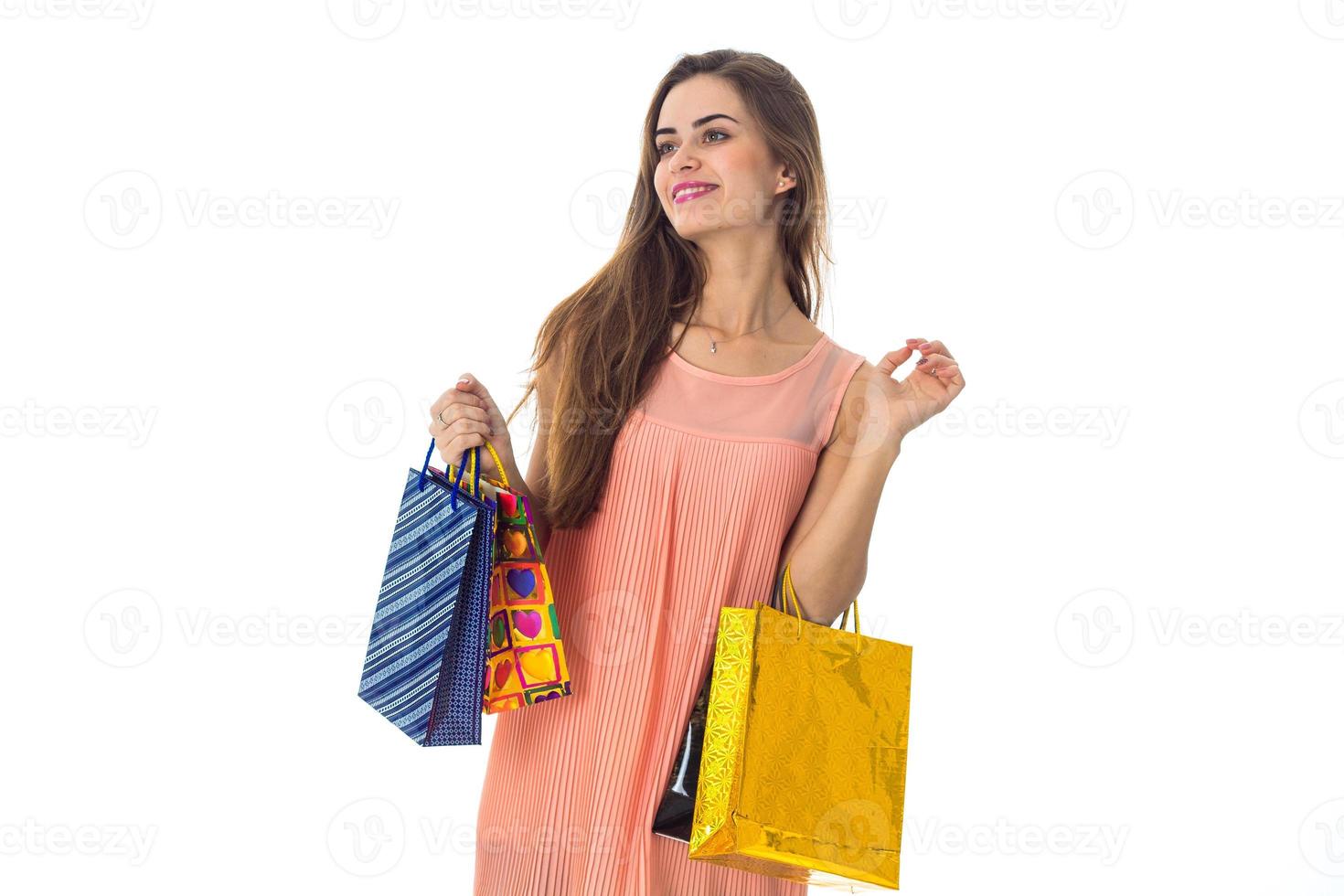 young girl stands with gifts in hands looks away and smiling isolated on white background photo