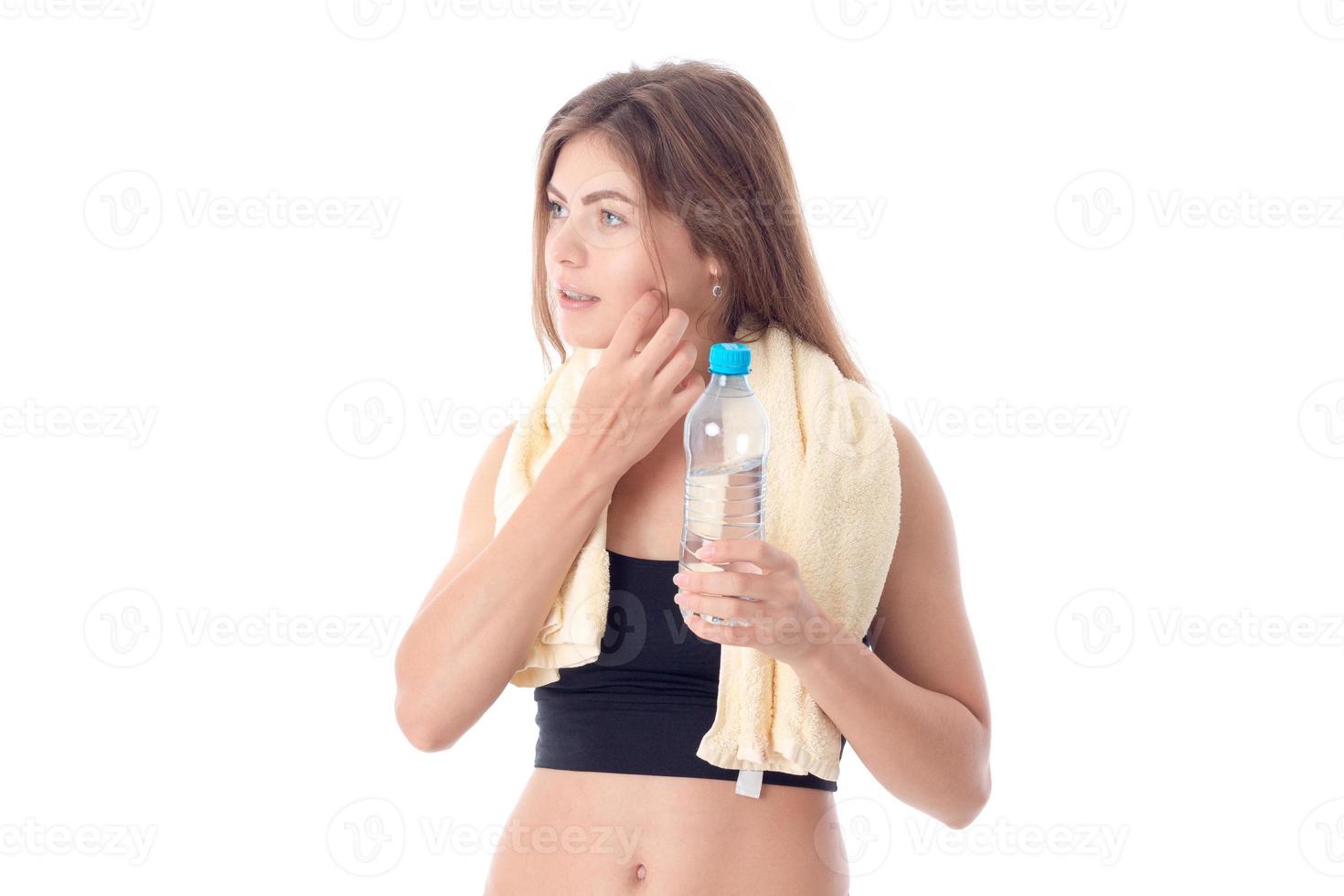 Slim girl with towel on his shoulders holding a bottle isolated  white background photo