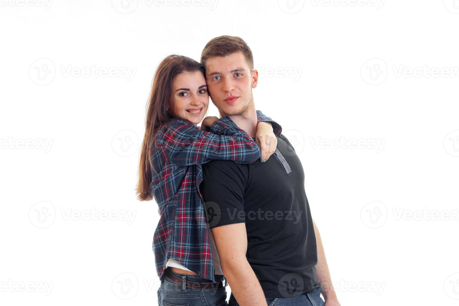 a charming young couple standing together looking at camera and smiling photo
