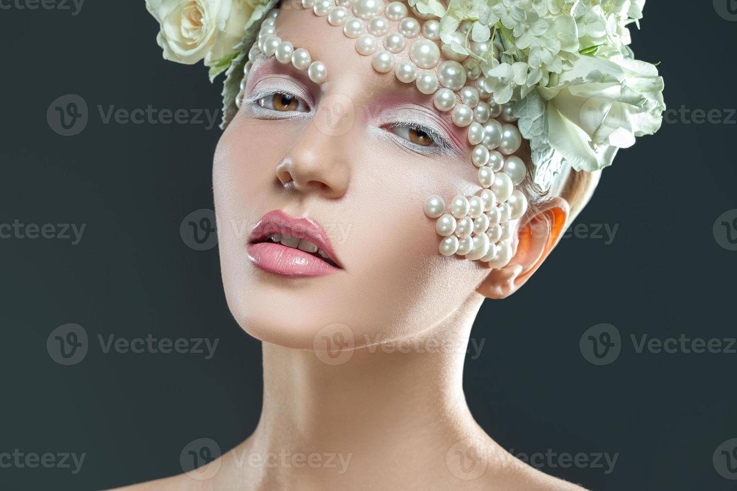 dulce mujer joven con tierno maquillaje rosa y blanco mirando a la cámara foto