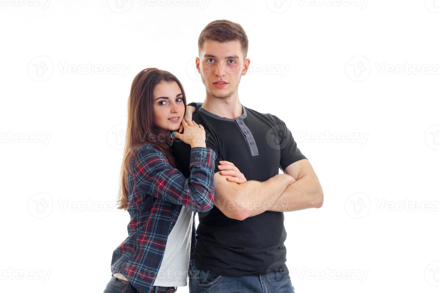 smiling delightful brunette hugs over the shoulder of a handsome guy photo