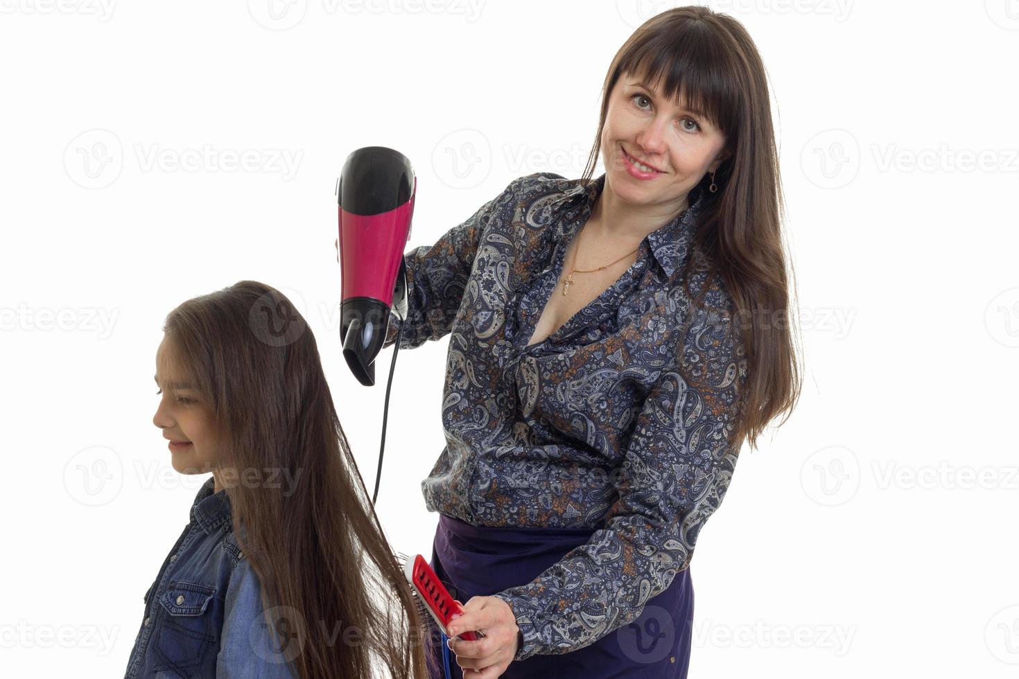 Cheerful mother makes a hairstyle to her little daughter photo