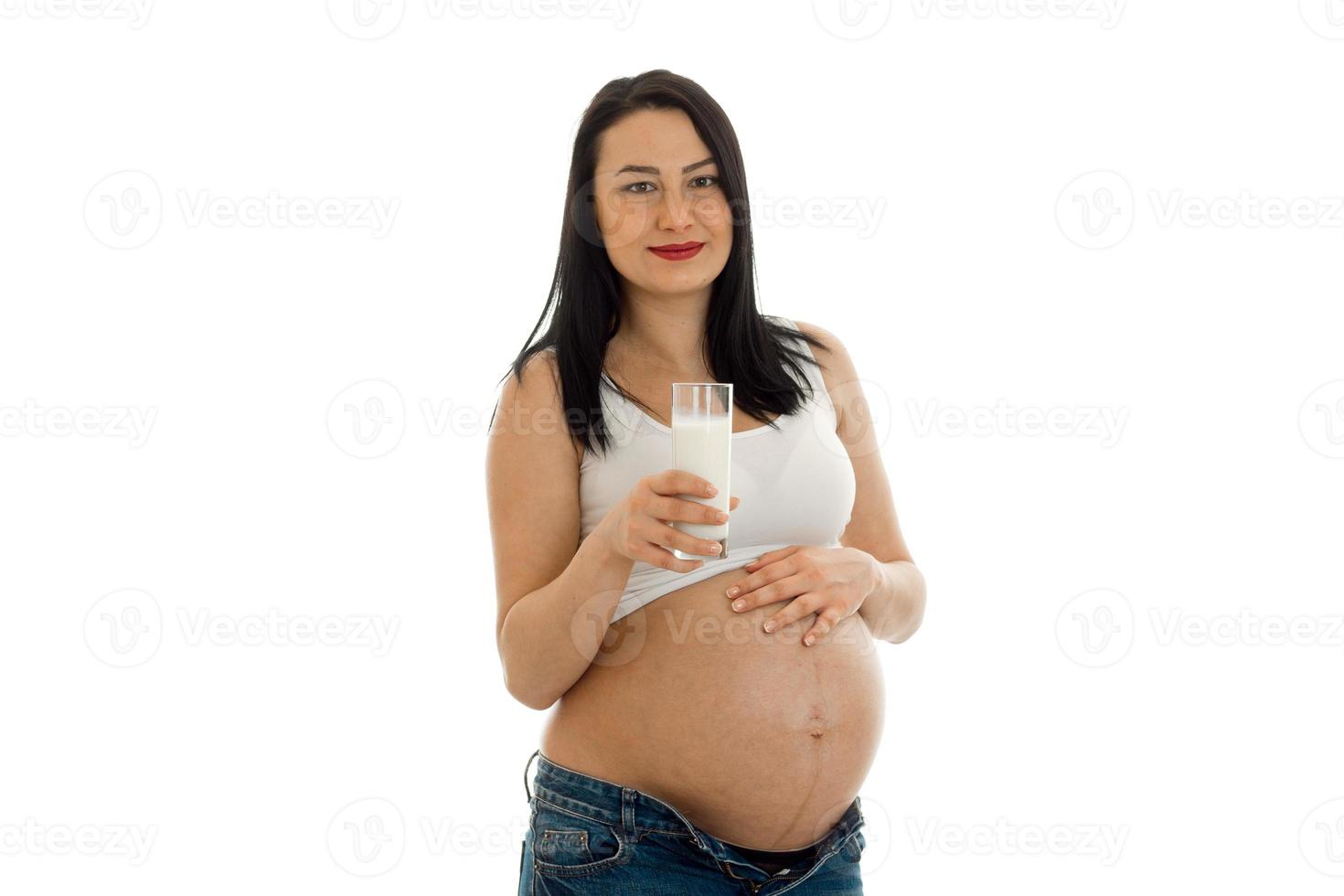 young pregnant brunette girl with glass of milk looking at the camera isolated on white background photo