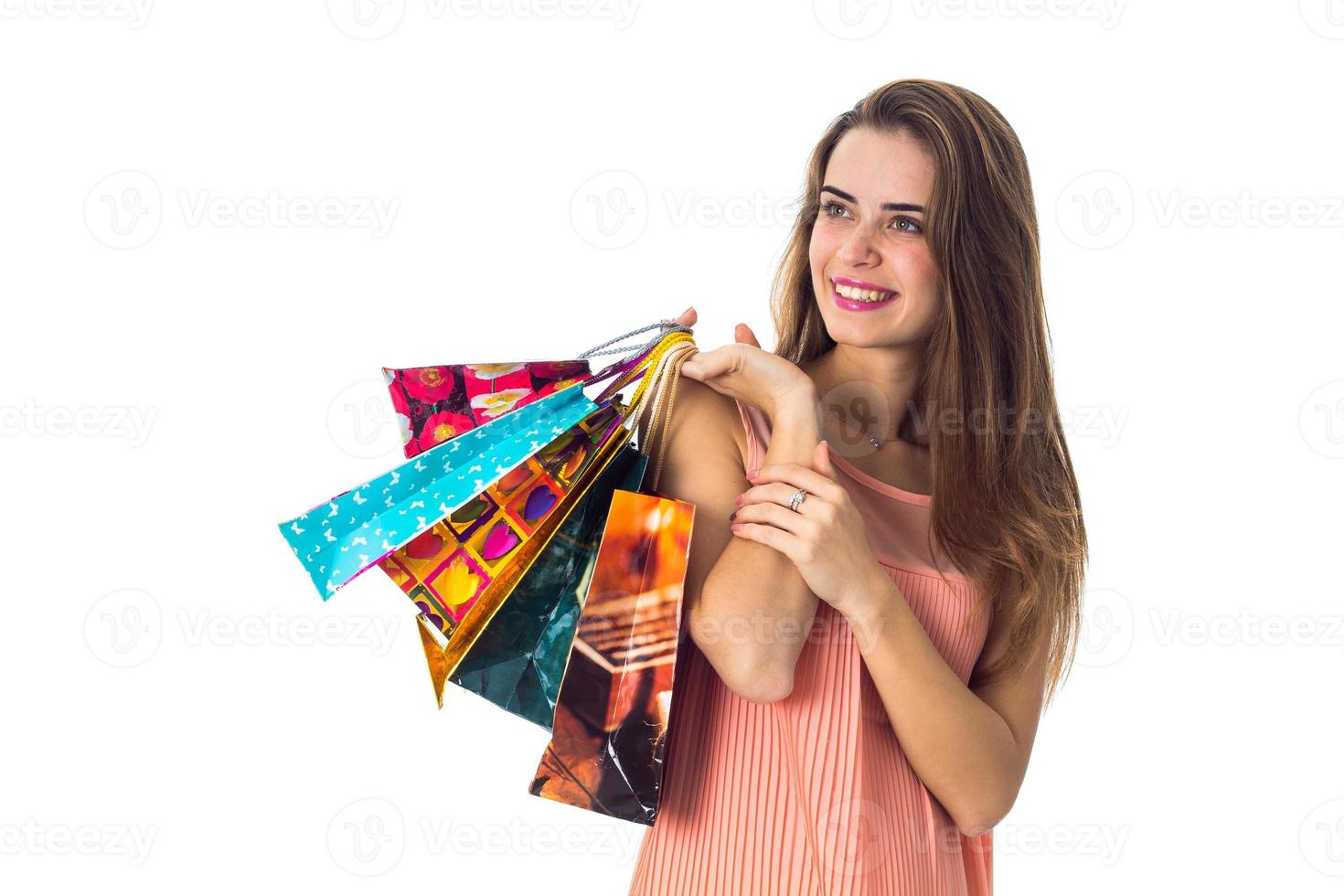 smiling girl looks away and raised in the hands of a beautiful bright packages photo