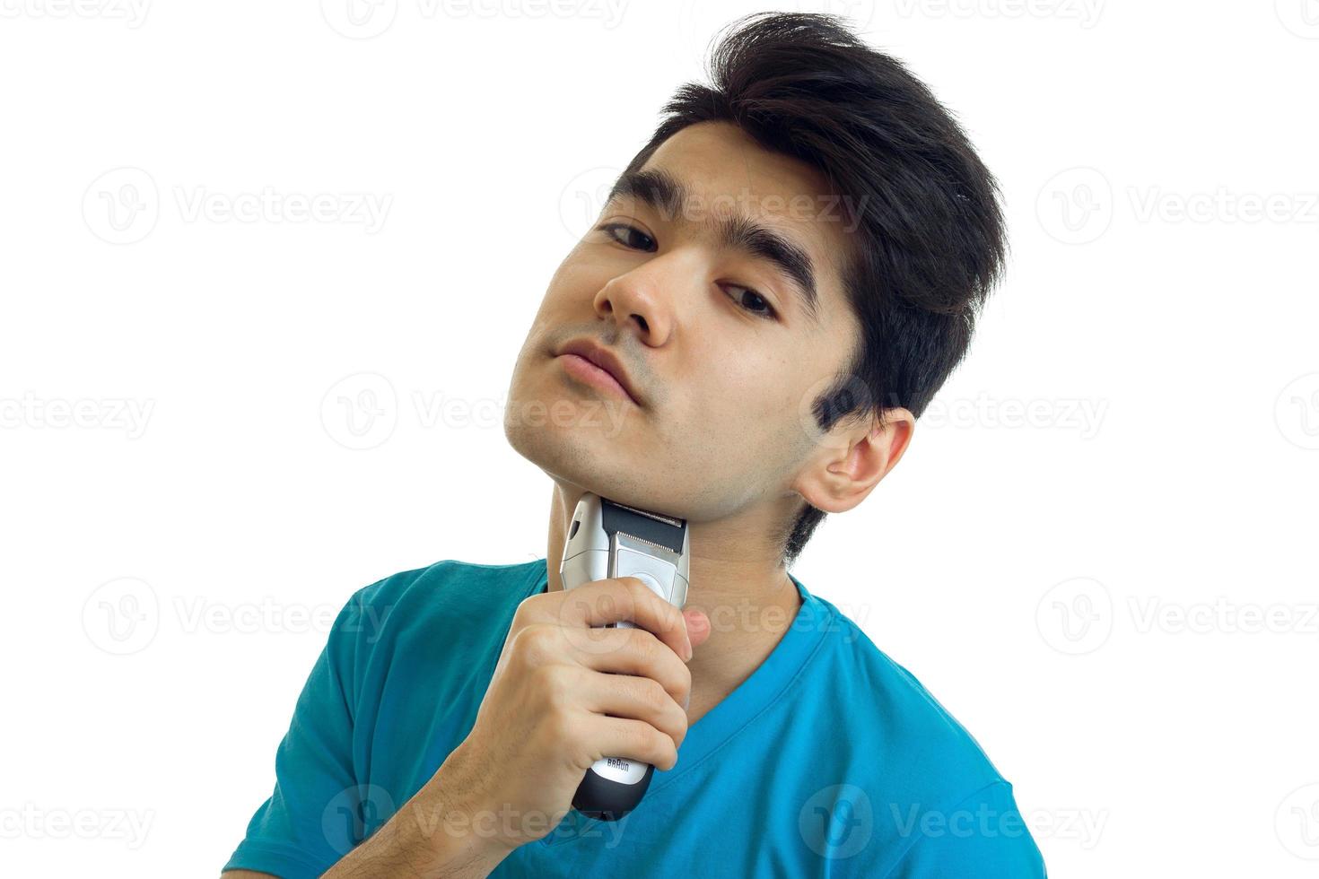 handsome young guy raised his head up and shaves his beard close-up photo