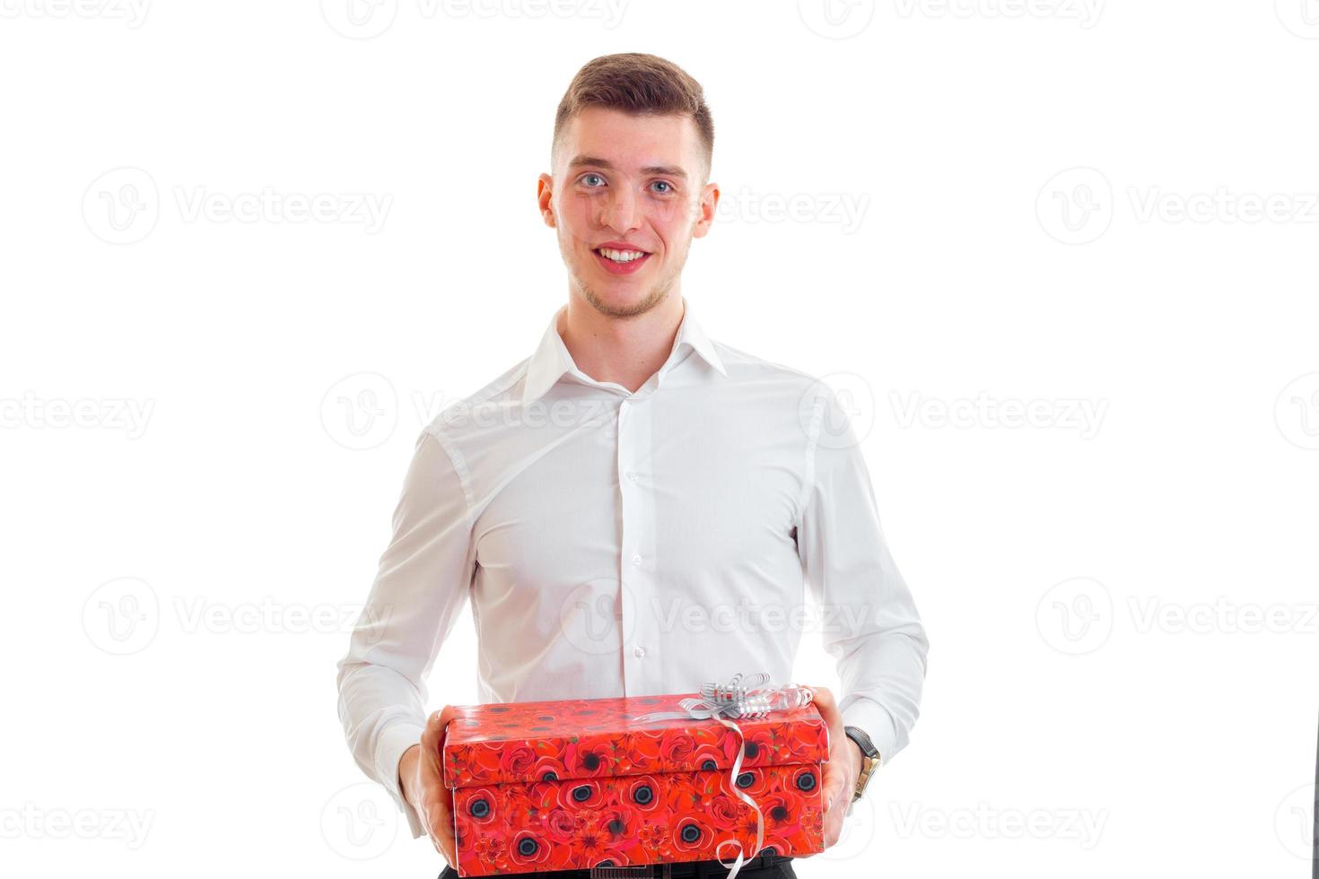 hilarious lovable guy looks straight and holding a gift photo