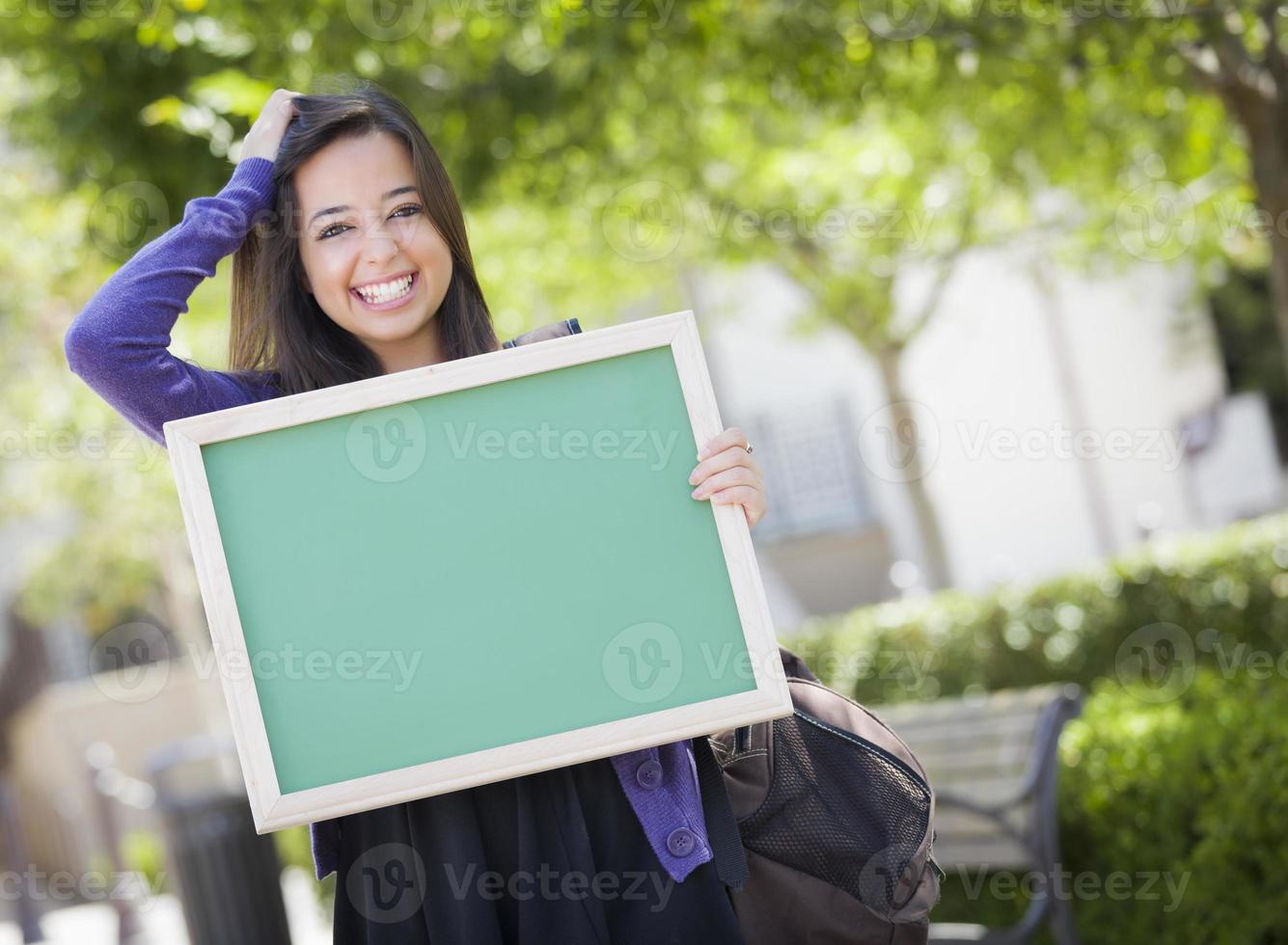 Excited Mixed Race Female Student Holding Blank Chalkboard photo